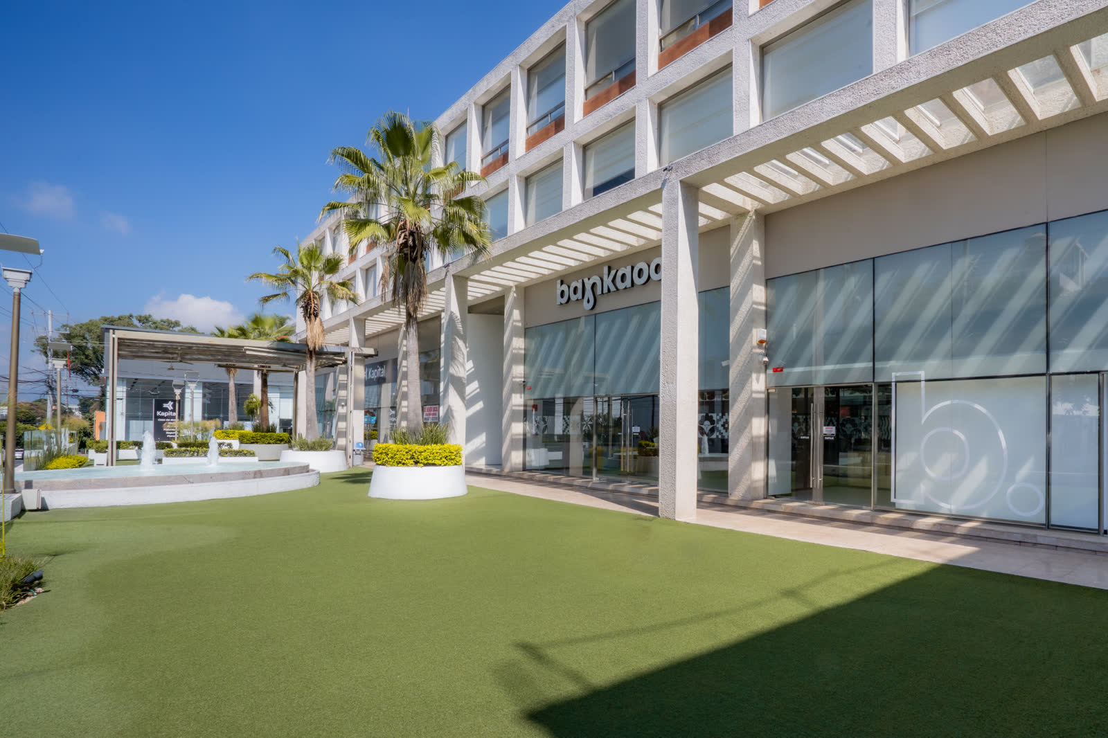 Fachada con fuente y locales comerciales